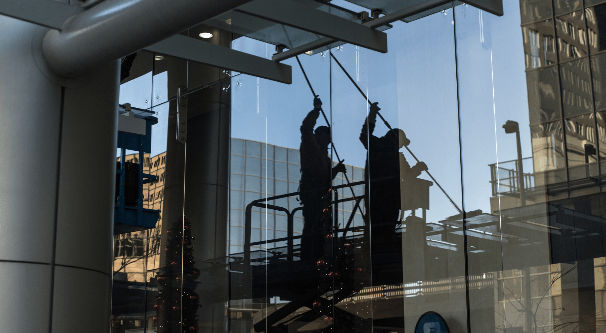 person on a lift cleaning the windows of a commercial office building